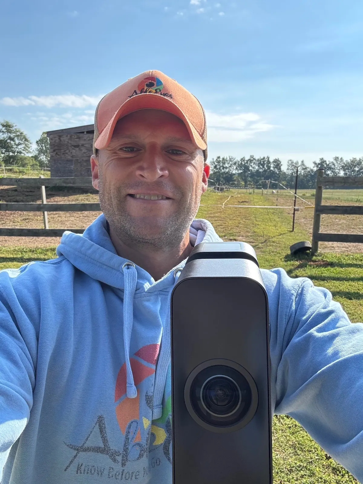 Founder holding a 360 camera while capturing a virtual tour outdoors.